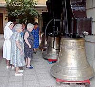 Varios vecinos observan las campanas tras su restauración